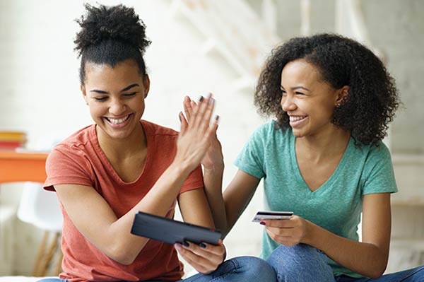 woman and her friend high five each other after loan approval