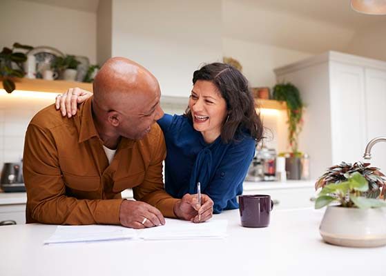 careers-mature-couple mature couple signing their retirement paperwork in their kitchen