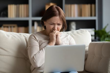 upset hispanic older woman dealing with a scam