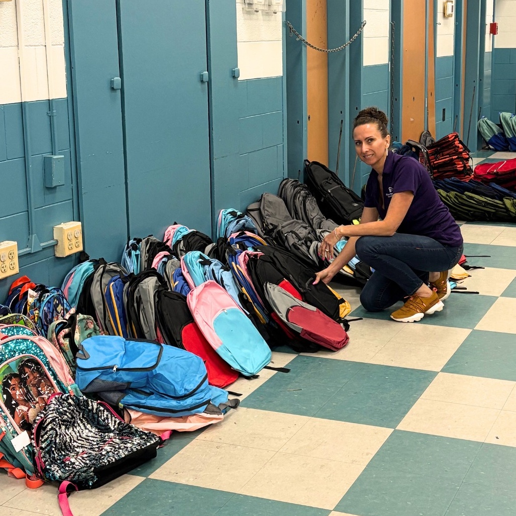woman organizing donated backpacks